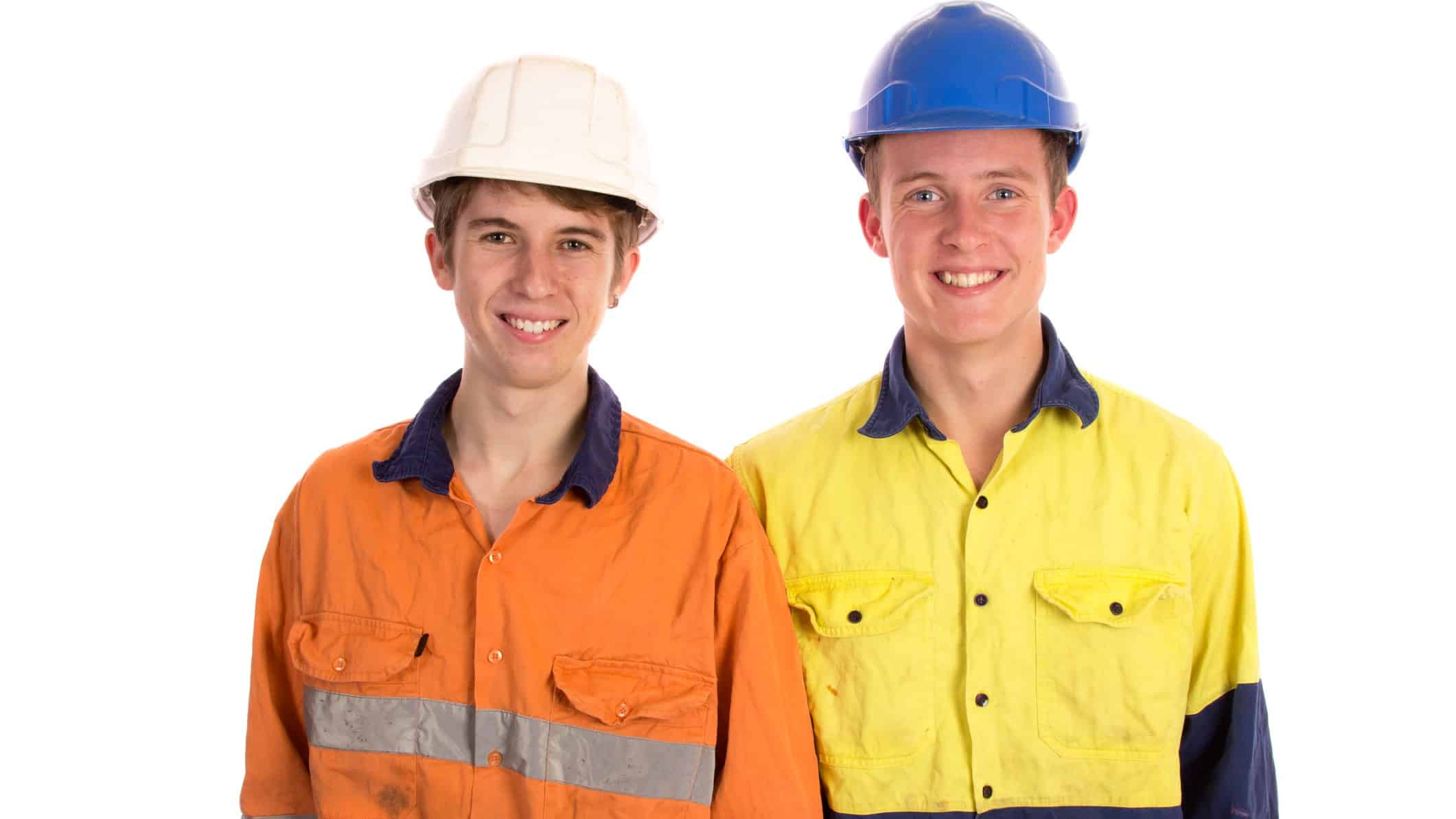 two young mining apprentices wearing their high visibility gear and hard hats stand together smiling.