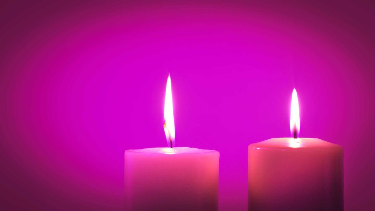 Two pink pillar candles lit and shown with a pink background indicating rosy news for the Dusk share price
