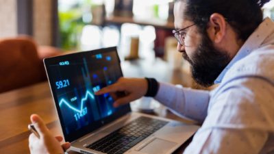 A man analyses stockmarket graph on his computer.