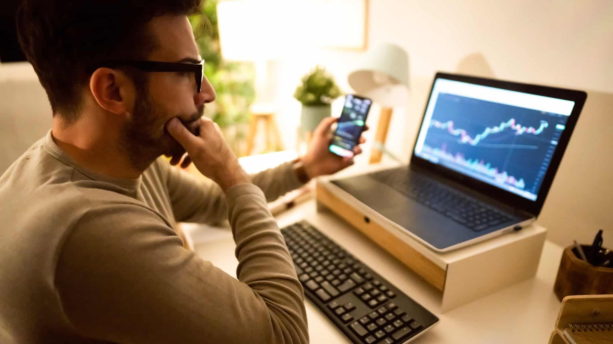 A man analyses stockmarket graph on his computer.