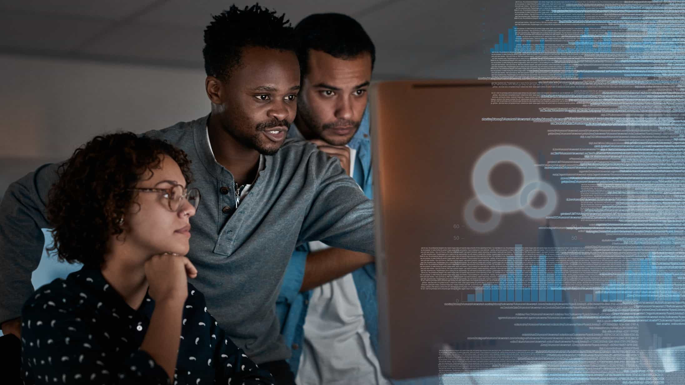 three people gather around a large computer screen where they are looking at something that is captivating their interest with a graphic image of data and digital technology material superimposed to the right hand third of the image.
