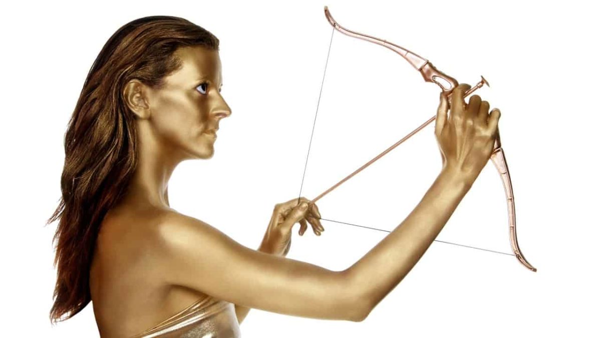 A golden woman shoots a bow and arrow high.