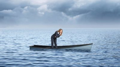 A businesswoman ponders why her boat is sinking in the ocean.