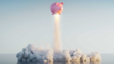 A piggy bank blasts off into the sky.