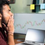 Investor looking at falling ASX share price on computer screen.