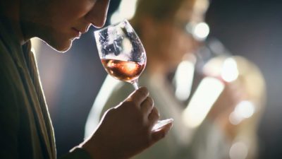 A woman sniffs a glass of win as part of a wine-tasting event