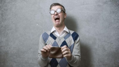 A man with Coke-bottle glasses and a checkered knit vest cries out in pain as he opens his purse and finds no money.