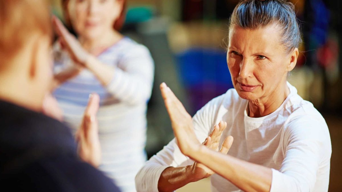Two mature women learn karate for self defence.