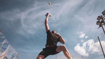 A tennis player returns service, sending the ball back where it came from.