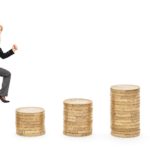 A businesswoman in a suit and holding a briefcase marches higher as she steps from one stack of coins to the next.