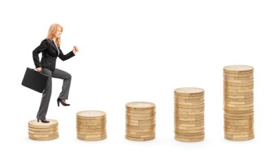 A businesswoman in a suit and holding a briefcase marches higher as she steps from one stack of coins to the next.