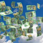 One hundred dollar notes blowing in the wind, representing dividend windfall.