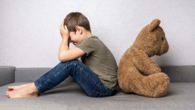 A child covering his eyes hiding from a toy bear representing a bear market for ASX shares