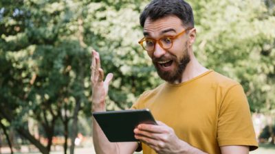 A man reacts with surprise when her see a bargain price on his phone.