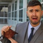 Man looks upset as he holds an empty wallet.
