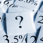 Pieces of paper with percetage rates on them and a question mark.