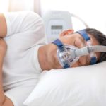 Man with a sleep apnoea mask on whilst sleeping.