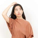 A woman scratches her head, thinking is this a no-brainer?