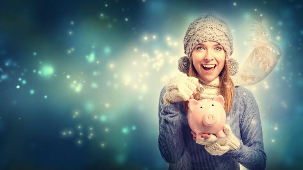 A woman puts money in her piggy bank all rugged up for the winter cold.