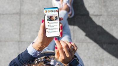 a woman using twitter on her mobile phone