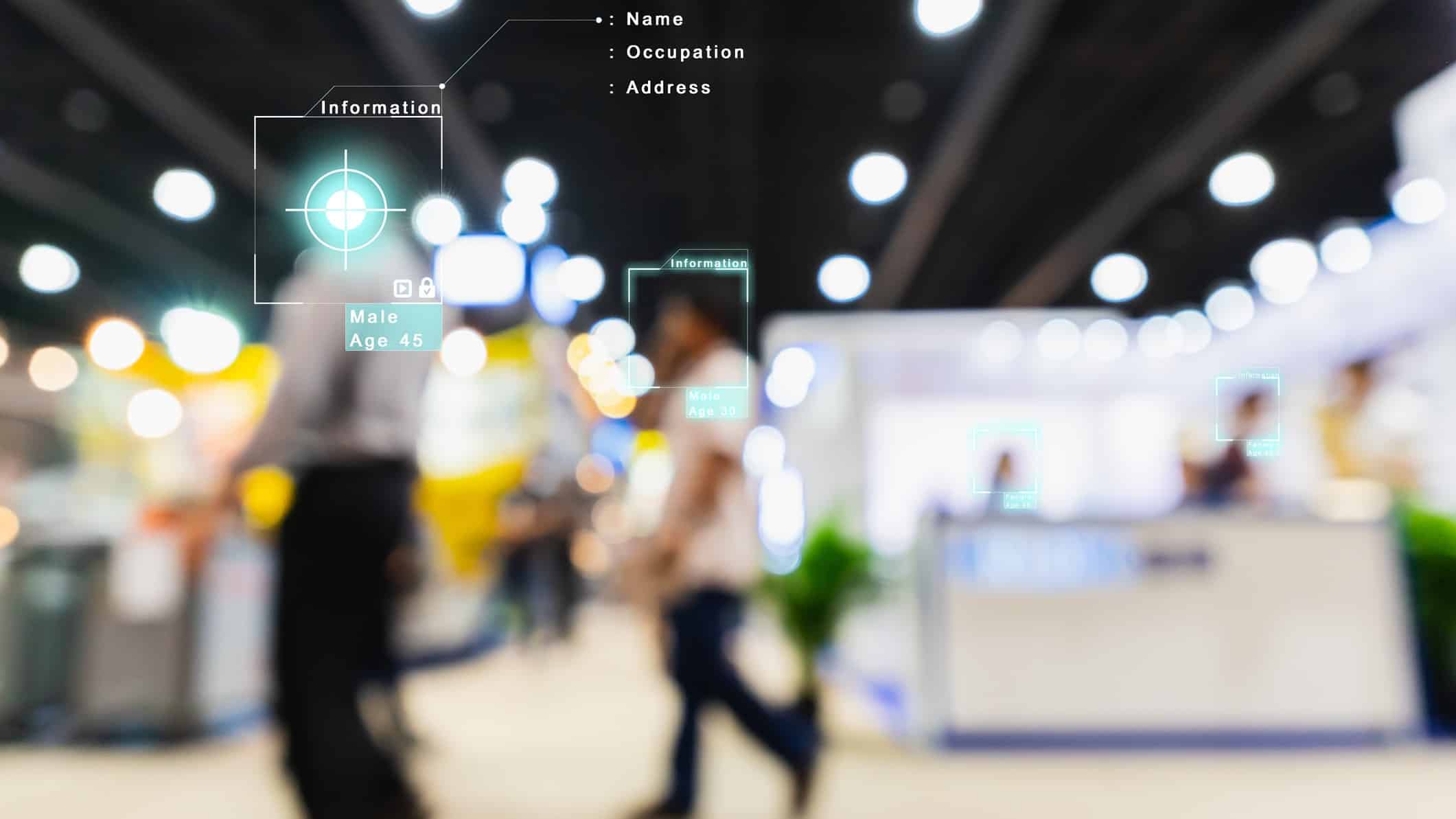 A deliberately blurred shot of shoppers inside a retail setting with facial recognition technology data superimposed on their faces, identifying their genders, ages and other biometric data.