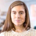 A woman's face is superimposed with the lines and point markings of facial recognition technology.