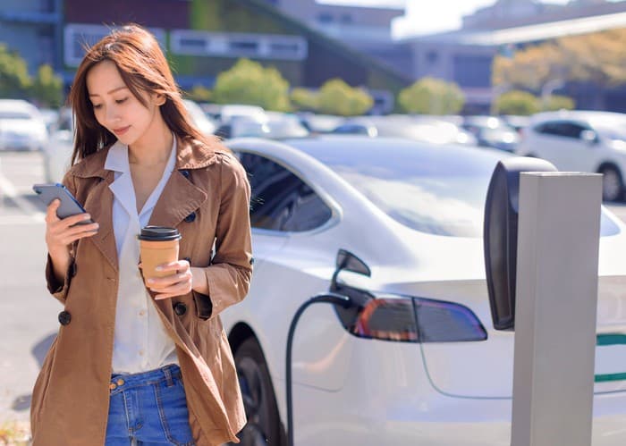 woman with coffee on phone with Tesla