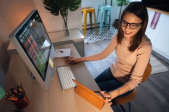 Smiling woman at desktop and tablet