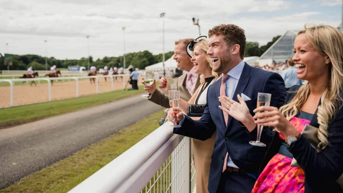 a group of people excitedly cheering at a horse race