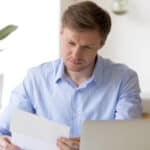 Man sitting in front of a laptop and analysing an earnings report.