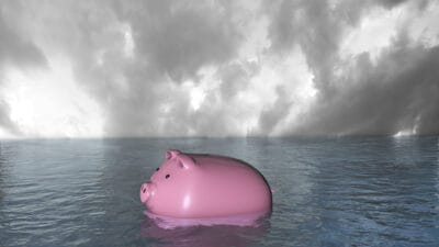 Piggy bank sinking in water symbolising a record low share price.