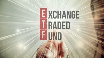 Exchange-traded fund spelt out with ETF in red and a person pointing their finger at it.