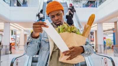 Man looking at his grocery receipt, symbolising inflation.