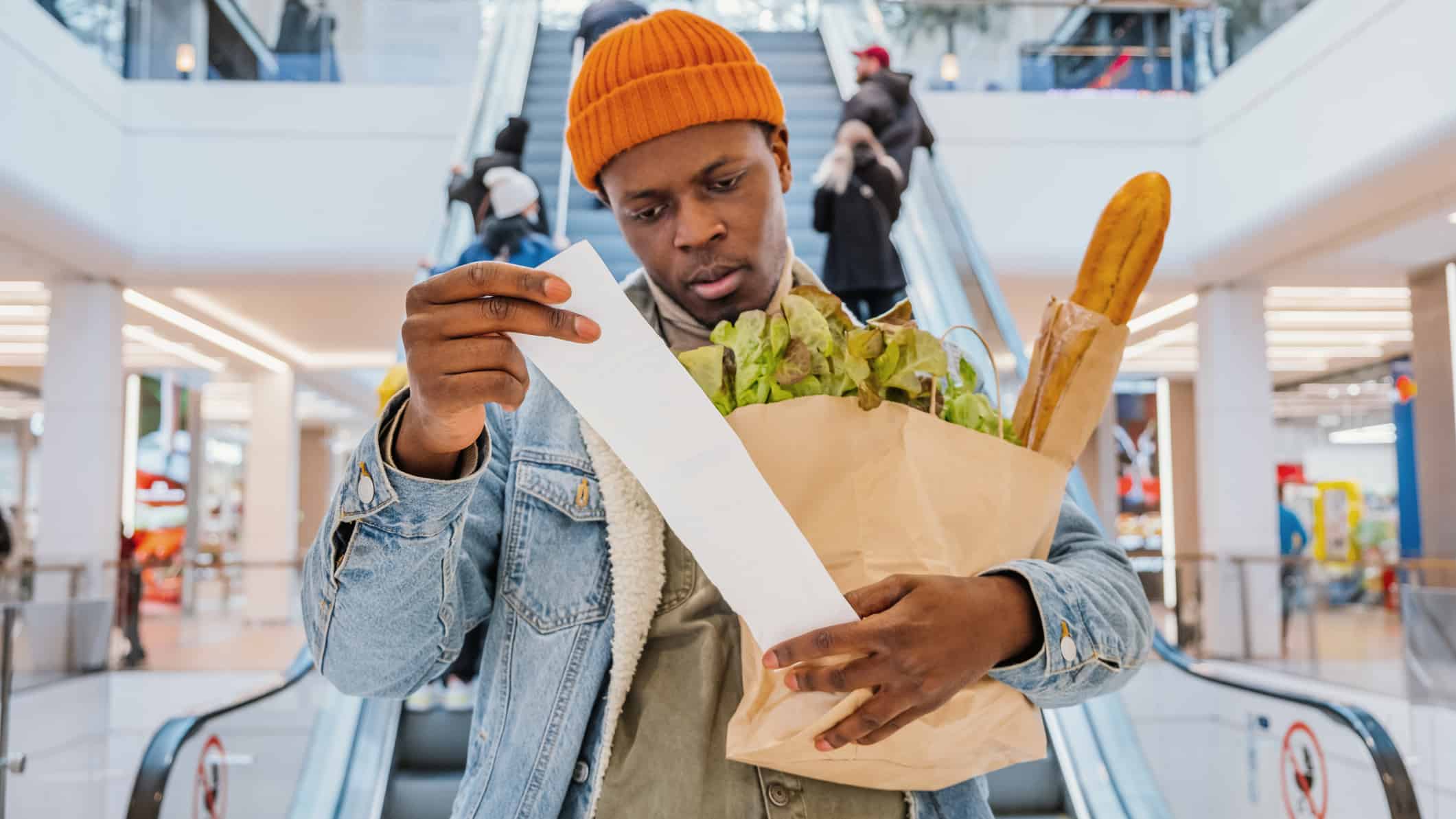 Man looking at his grocery receipt, symbolising inflation.