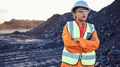 Copal miner standing in front of coal.