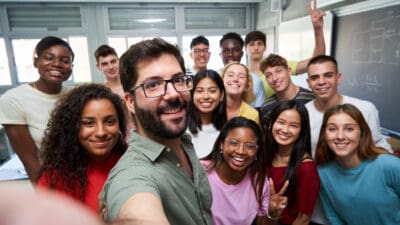 People of different ethnicities in a room taking a big selfie, symbolising diversification.