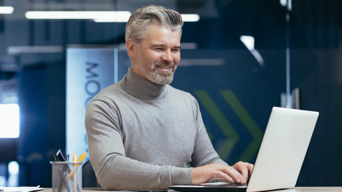 Smiling man working on his laptop.