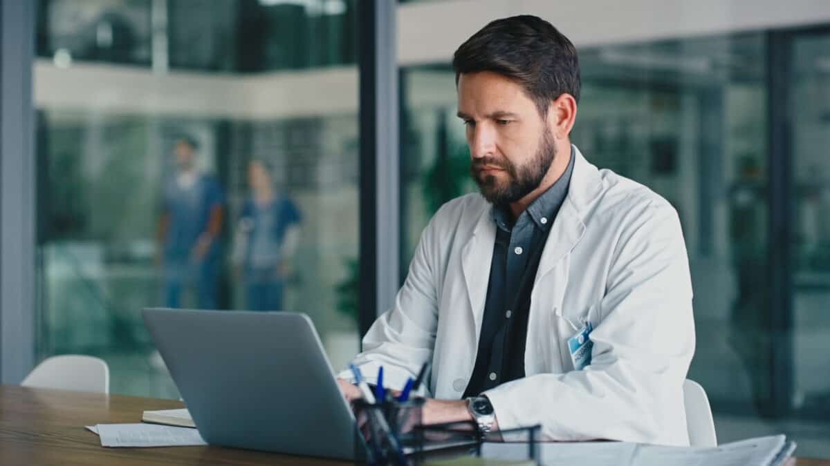 Health professional looking at a laptop.