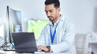 Health professional working on his laptop.