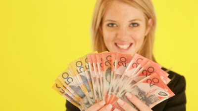 Woman holding $50 and $20 notes.