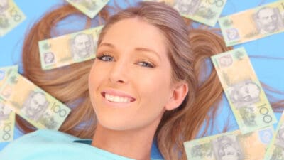 Woman laying with $100 notes around her, symbolising dividends.