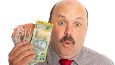 Man holding Australian dollar notes, symbolising dividends.