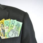 Australian dollar notes in businessman pocket suit, symbolising ex dividend day.