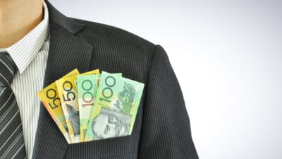 Australian dollar notes in businessman pocket suit, symbolising ex dividend day.