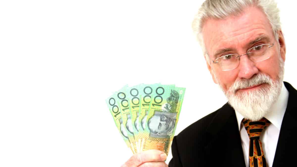 Man holding Australian dollar notes, symbolising dividends.