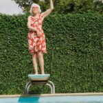 Retiree on a diving board with one fist pumped, symbolising retirement.