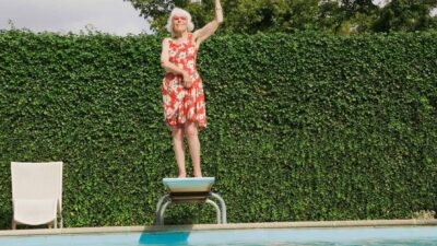 Retiree on a diving board with one fist pumped, symbolising retirement.