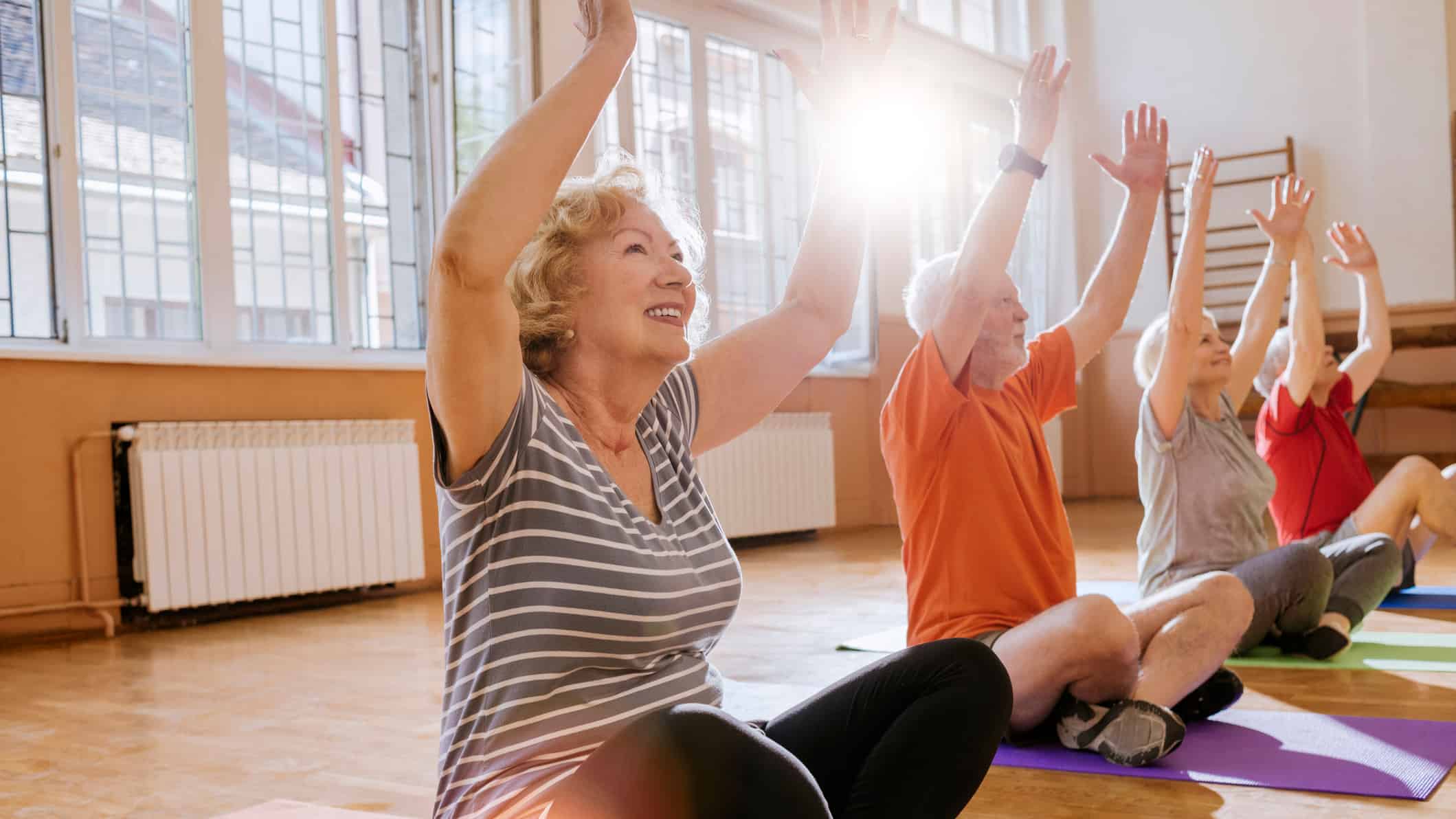 Group of retirees enjoying yoga, symbolising retirement.