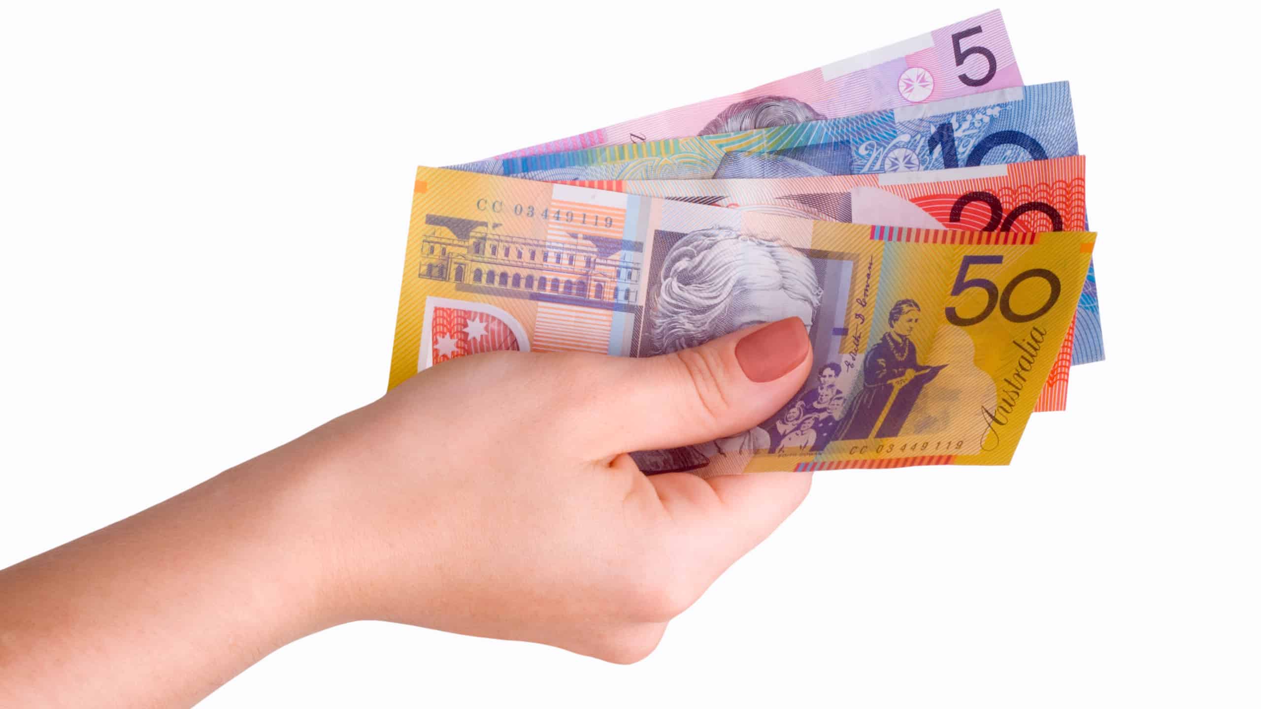 Hand with Australian dollar notes symbolising ex-dividend date.