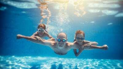 Father in the ocean with his daughters, symbolising passive income.